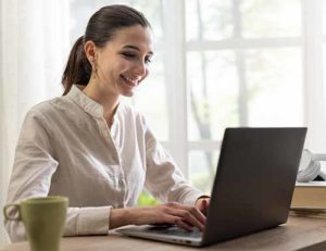 Woman smiling and working on laptop
