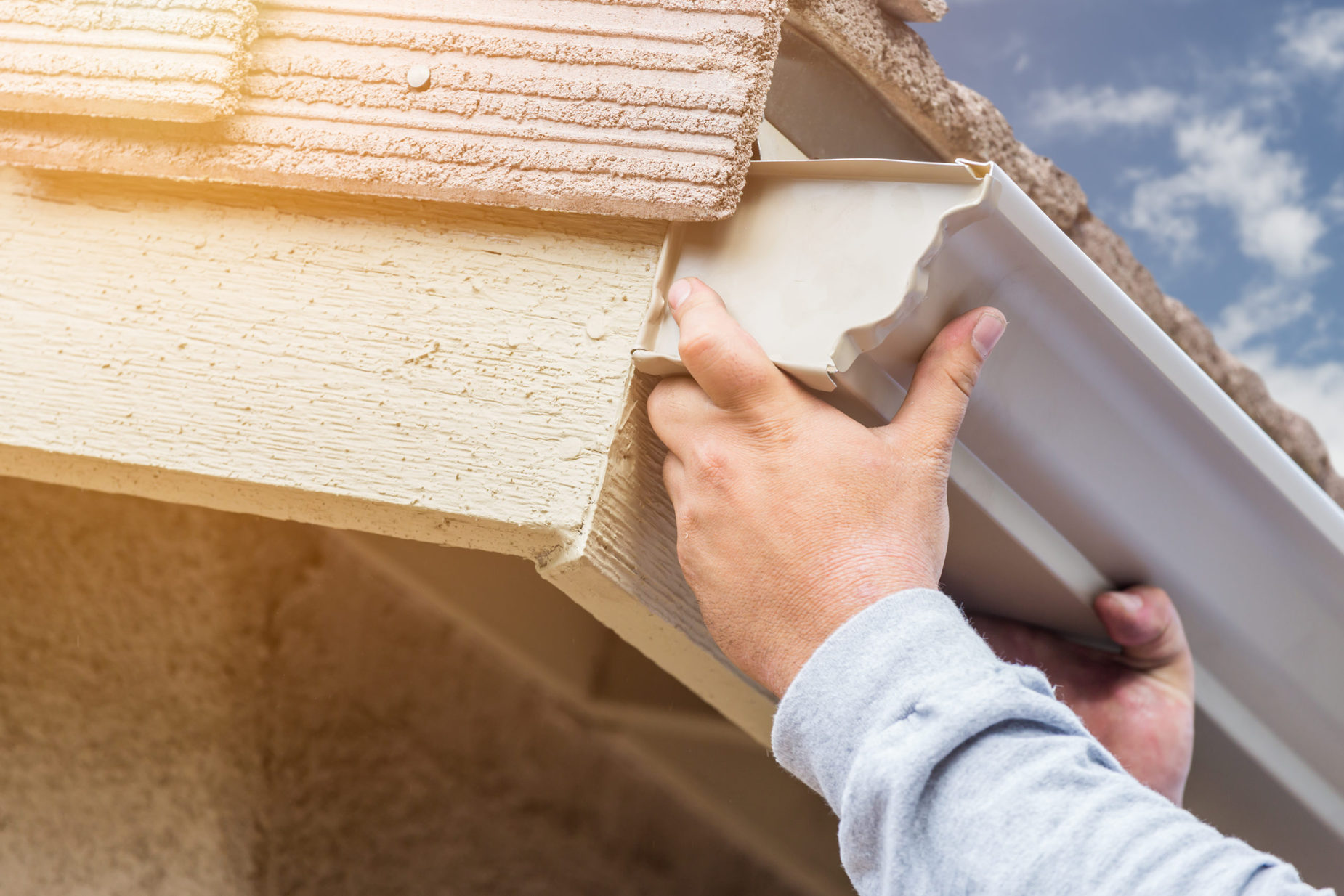 Worker,Attaching,Rain,Gutter,To,Fascia,Of,House.