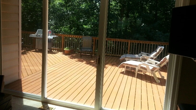Sliding glass door overlooking a deck with lounge chairs and a grill
