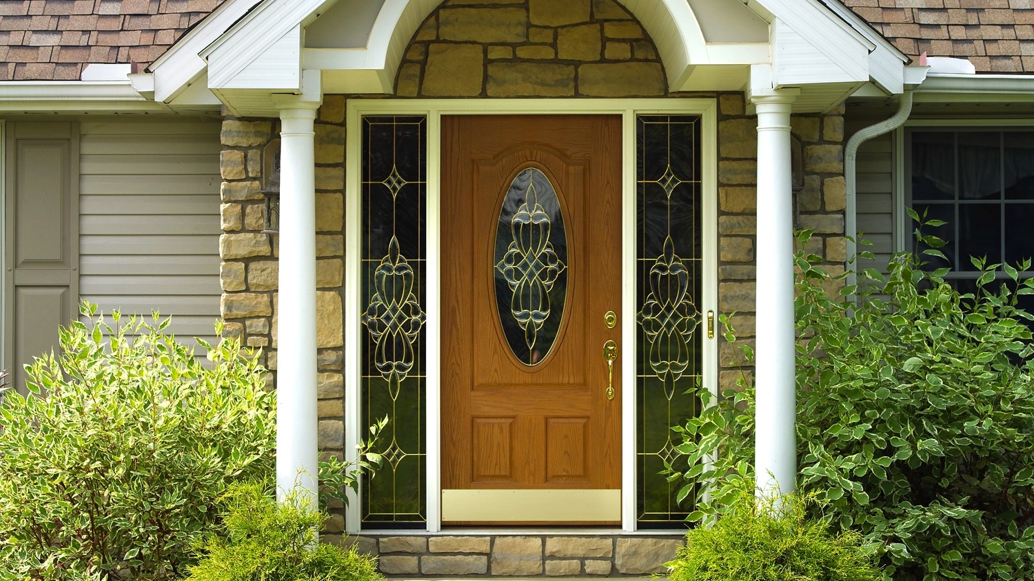 Brown front entry door with decorative glass and matching sidelights